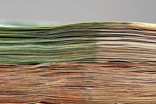 Close-up of a stack of paper bills, side view. Euro banknotes stacked on top of each other. Big pile of money