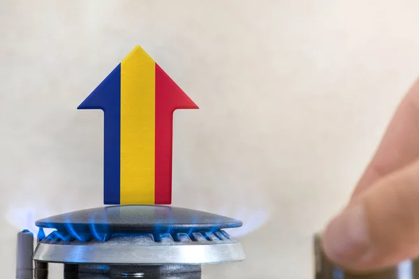 Gas price. Rise in gas prices in Romania. A burner with a flame and an arrow up, painted in the colors of the Romania flag. The concept of rising gas or energy prices