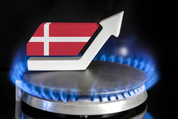Gas price. Rise in gas prices in Denmark. A burner with a flame and an arrow up, painted in the colors of the Denmark flag. The concept of rising gas or energy prices