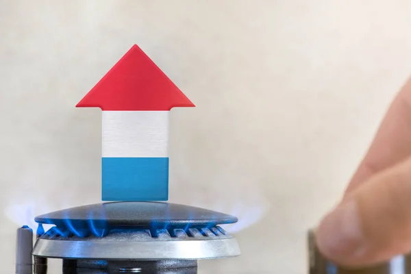 Gas price. Rise in gas prices in Luxembourg. A burner with a flame and an arrow up, painted in the colors of the Luxembourg flag. The concept of rising gas or energy prices