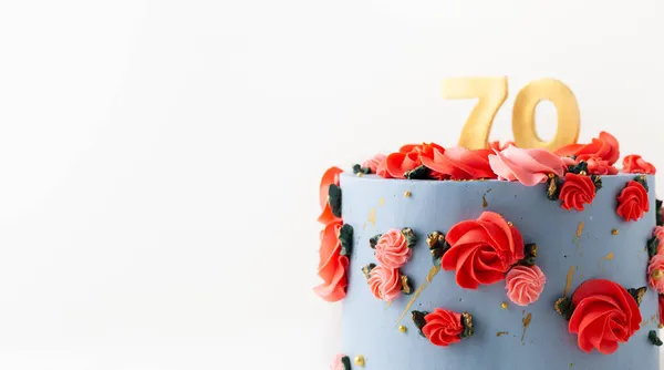 白い背景に赤い花で飾られた青いクリームチーズの霜が付いている誕生日ケーキ 七十年記念 — ストック写真
