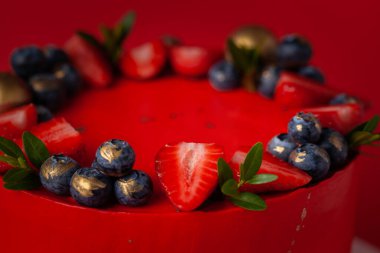 Büyük bir olay için krem peynirli kırmızı pasta. Altın süslemeli lüks pasta ve kırmızı arka planda böğürtlenler.