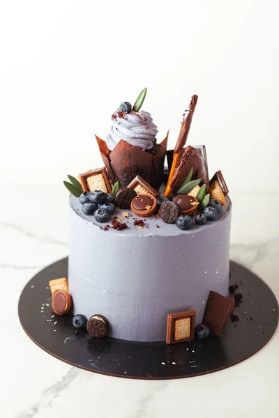 Verjaardagstaart Met Paarse Roomkaas Glazuur Versierd Met Cupcake Bosbessen Chocoladekoekjes — Stockfoto
