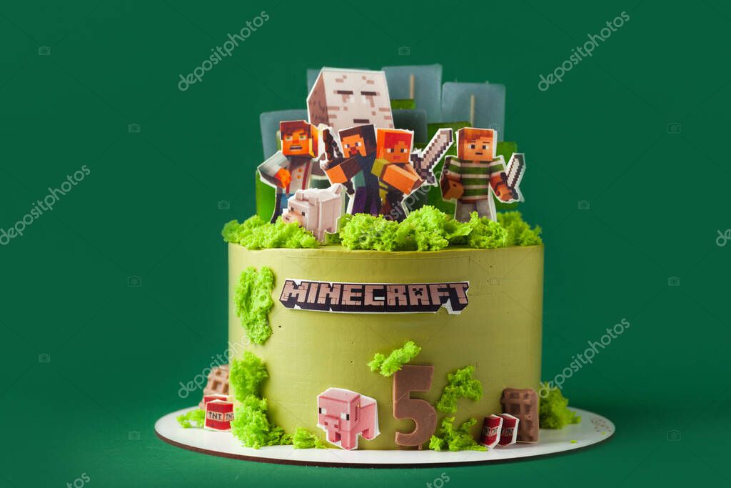 Kyiv, Ukraine - June 09, 2021: Birthday cake for a fan of Minecraft game on the green background. Cake for a gameboy decorated with edible green grass