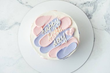 Mavi ve pembe krem peynirli Bento keki ve üstünde mutlu yıllar mesajı. Beyaz arka planda doğum günü pastası. Asya 'da küçük pasta eğilimi.