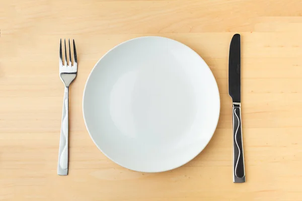 用金属刀叉和刀叉把空白的白盘放在木制桌子上 餐厅菜单的背景 带有文本的复制空间 — 图库照片