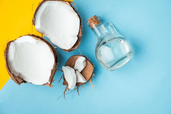 Cracked Coconut Coconut Oil Glass Bottle Yellow Blue Background — Foto de Stock