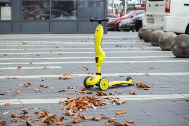 Issız sokaktaki küçük bir çocuk için scooter. Etrafta kimse yok. Scooter sürerken güvenlik