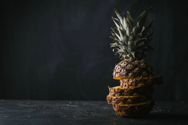 Kypsä Ananas Leikataan Paloiksi Mustalla Pohjalla — kuvapankkivalokuva