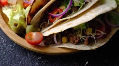 Sebzeli ve limonlu mısır tortilla soslu domuz carnitas sokak tacoları. Geleneksel Meksika yemekleri siyah arka planda, tahta tabakta.