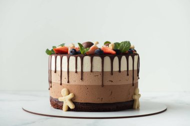 Üzerine yaban mersini, çilek ve çikolata serpiştirilmiş üç çikolata. Beyaz arkaplan.