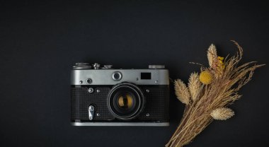 Siyah arka planda eski bir retro kamera. Fotoğraf meraklısı biri için şık bir geçmiş. Düz yatıyordu