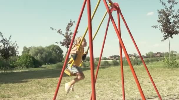 Menina Feliz Sorrindo Montando Balanço Das Crianças Parque Movimento Lento — Vídeo de Stock