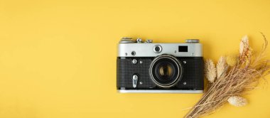 Sarı arka planda eski bir retro kamera. Fotoğraf meraklısı biri için şık bir geçmiş. Düz yatıyordu