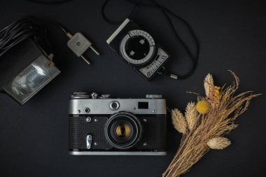 Siyah arka planda retro kamera. Fotoğraf için eski teçhizat. Fotoğraf meraklısı biri için şık bir geçmiş. Düz yatıyordu
