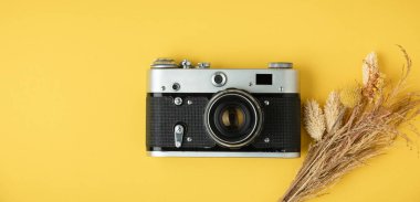 Sarı arka planda eski bir retro kamera. Fotoğraf meraklısı biri için şık bir geçmiş. Düz yatıyordu