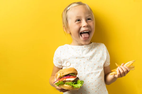 Słodka Mała Biała Dziewczyna Blond Włosami Ciesząca Się Hamburgerem Żółtym — Zdjęcie stockowe