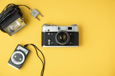 Sarı arka planda retro kamera. Fotoğraf için eski teçhizat. Fotoğraf meraklısı biri için şık bir geçmiş. Düz yatıyordu