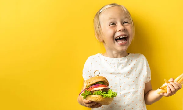 Słodka Mała Biała Dziewczyna Blond Włosami Ciesząca Się Hamburgerem Żółtym — Zdjęcie stockowe