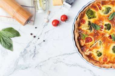 Domates, fesleğen ve brokoliyle süslenmiş tavuklu kiş. Beyaz mermer zemin üzerinde kısa kabuklu pasta tabanlı Fransız turtası