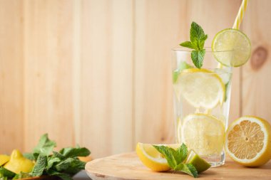 Naneli, limonlu ve limonlu mojito. Kırsal ahşap arka planda bir bardakta. Buzlu soğuk yaz içkisi