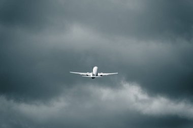 Kalkıştan sonra bulutlu havada uçan yolcu uçakları. Yüklü kümülonimbus bulutları var. İş gezisi. Macera ve yolculuk kavramı.