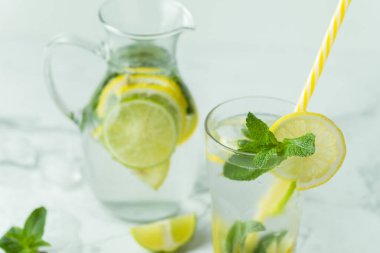 Beyaz arka planda cam bardakta naneli ve limonlu mojito kokteyli. Buzlu soğuk yaz içkisi