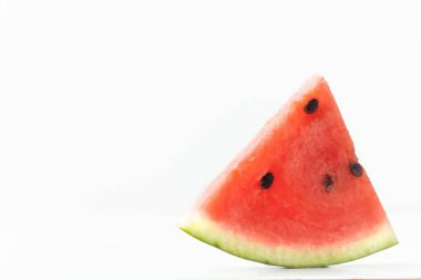Close up shot of triangular ripe slice of watermelon isolated on white background. Hot summertime concept.