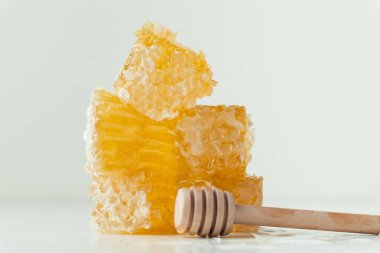 Honeycomb full of fresh honey in a white bowl. Honeycomb with honey deeper and wild flowers on the white background