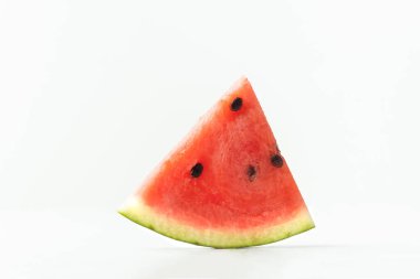 Close up shot of triangular ripe slice of watermelon isolated on white background. Hot summertime concept.