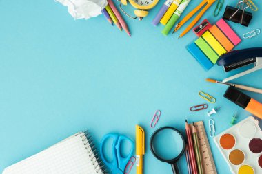 School and office supplies on the blue pastel background. Back to school concept on September day. Flat lay. Free space.