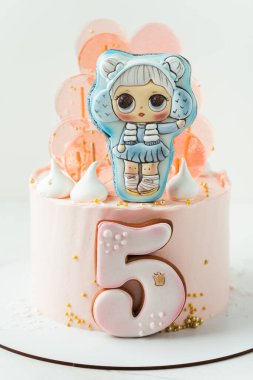 Kyiv, Ukraine - August 05: LOL Surprise character doll LOL gingerbread cookie on the top of birthday cake for a little girl on the white background