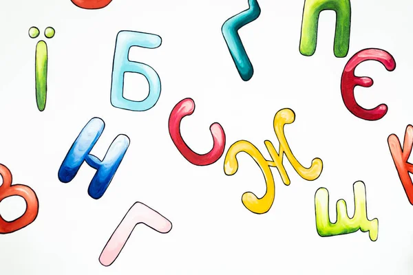 Ukrainian alphabet painting on the white wall in the classroom. Multicolored letters drawing on white background