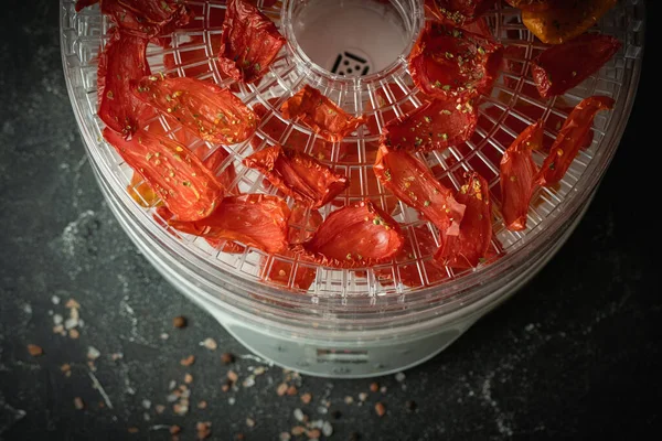 Tomato drying process in a food dehydrator. Homemade sun-dried tomatoes