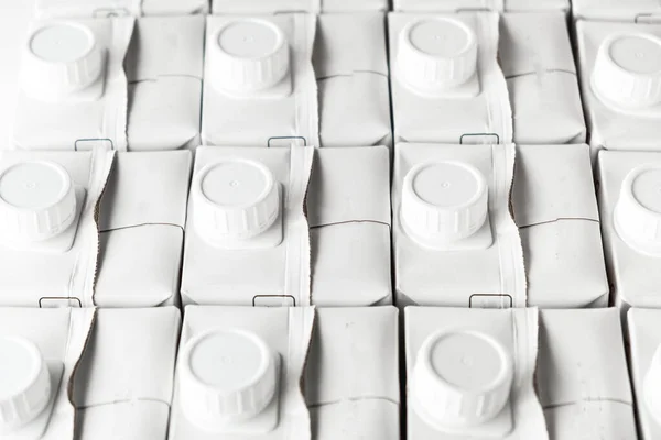 White blank packaging of milk. Stack of cardboard cartons with mock up for branding. A lot of packing for liquids on the white background