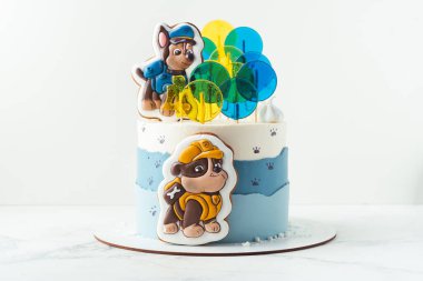 Kyiv, Ukrayna - 10 Ağustos - Paw Patrol animasyon televizyon dizisinin Chase ve Moloz köpek yavruları şeklinde zencefilli kurabiyelerle süslenmiş küçük bir hayranı için beyaz ve mavi doğum günü pastası