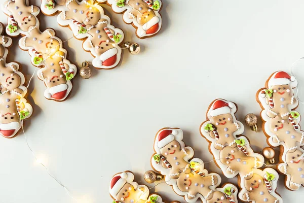 Lebkuchenmänner Mit Festlichem Zuckerguss Weihnachtsplätzchen Mit Lichtergirlanden Auf Weißem Hintergrund — Stockfoto