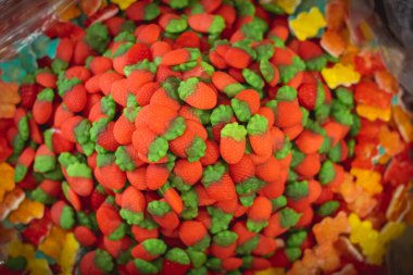 Şekerci dükkanının camında kocaman renkli çilek şekilli jöle yığını