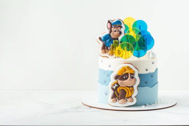 Kyiv, Ukrayna - 10 Ağustos - Paw Patrol animasyon televizyon dizisinin Chase ve Moloz köpek yavruları şeklinde zencefilli kurabiyelerle süslenmiş küçük bir hayranı için beyaz ve mavi doğum günü pastası