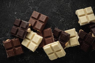 Kyiv, Ukrayna - 12 Eylül - Beyaz, Süt ve Karanlık Rittersport çikolataları siyah arka planda fındıkla ezildi. Düz yatıyordu