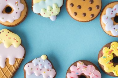 Dondurma şeklinde ev yapımı zencefilli kurabiye, çörek ve pastel renkli kekler. Eski moda pasta arka planı. Mavi arkaplan ile düz uzandı