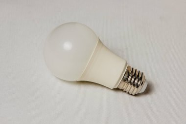 Arka planda büyük, enerji tasarrufu sağlayan bir ampul. yakın plan