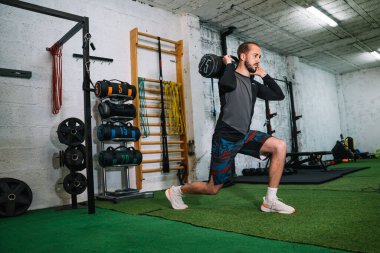 Delikanlı ağırlıkla çömeliyor.