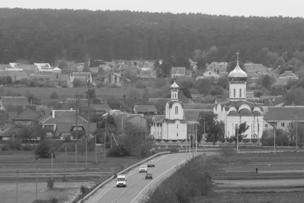 Ukrayna köyündeki Castle Hill ahşap evinin genel manzarası. Eski ahşap kilise. St. Vaftizci Yahya Kilisesi. Kenar mahallelerdeki kilise.