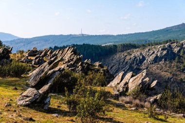 Kayalık dağ sırası ve sabah güneşiyle manzaralı bir yer.