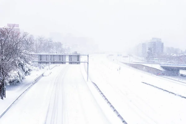Tomma motorvägen täckt av snö med instängda bilar under kraftig snöstorm — Stockfoto