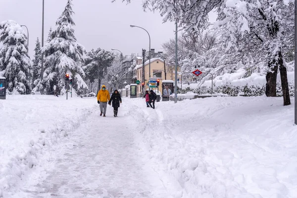 Människor på en stadsgata täckt av snö under kraftiga snöfall storm i Madrid — Stockfoto