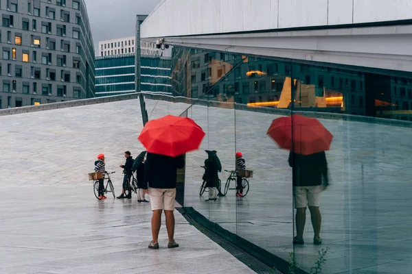 Oslo 'daki Opera binasında kırmızı şemsiyeli bir genç. — Stok fotoğraf
