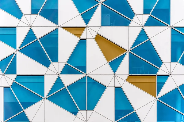 色ガラスとアルミニウムの不規則な部分を持つオフィスビルの未来的な抽象的なファサード — ストック写真