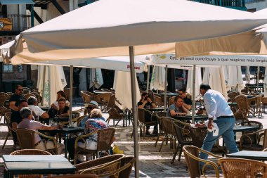 Madrid 'in Chinchon Belediye Başkanı Plaza' daki bir barın terasında eğlenen insanlar.
